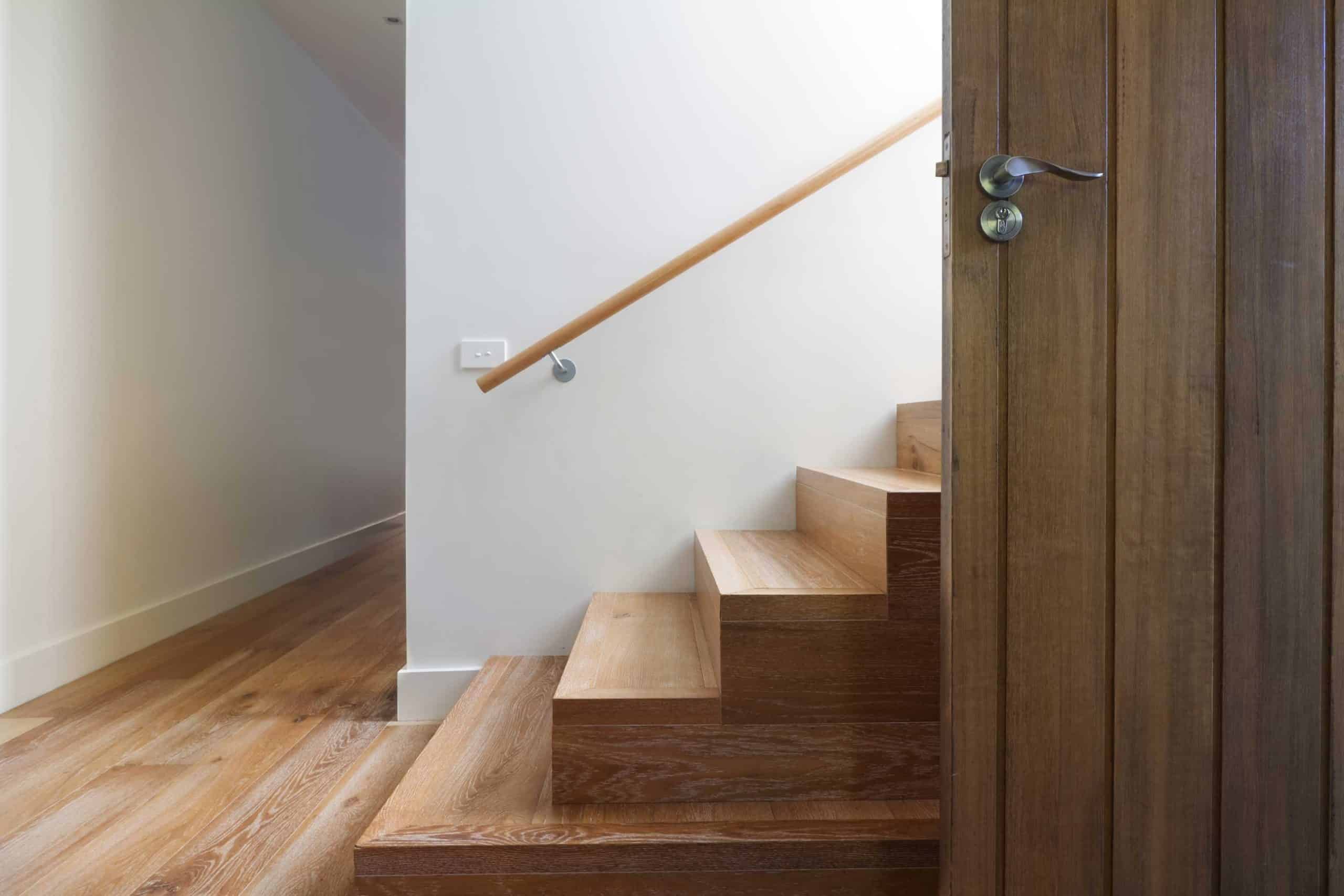 Modern timber staircase with a sleek handrail, crafted by a skilled builder in Wollongong.